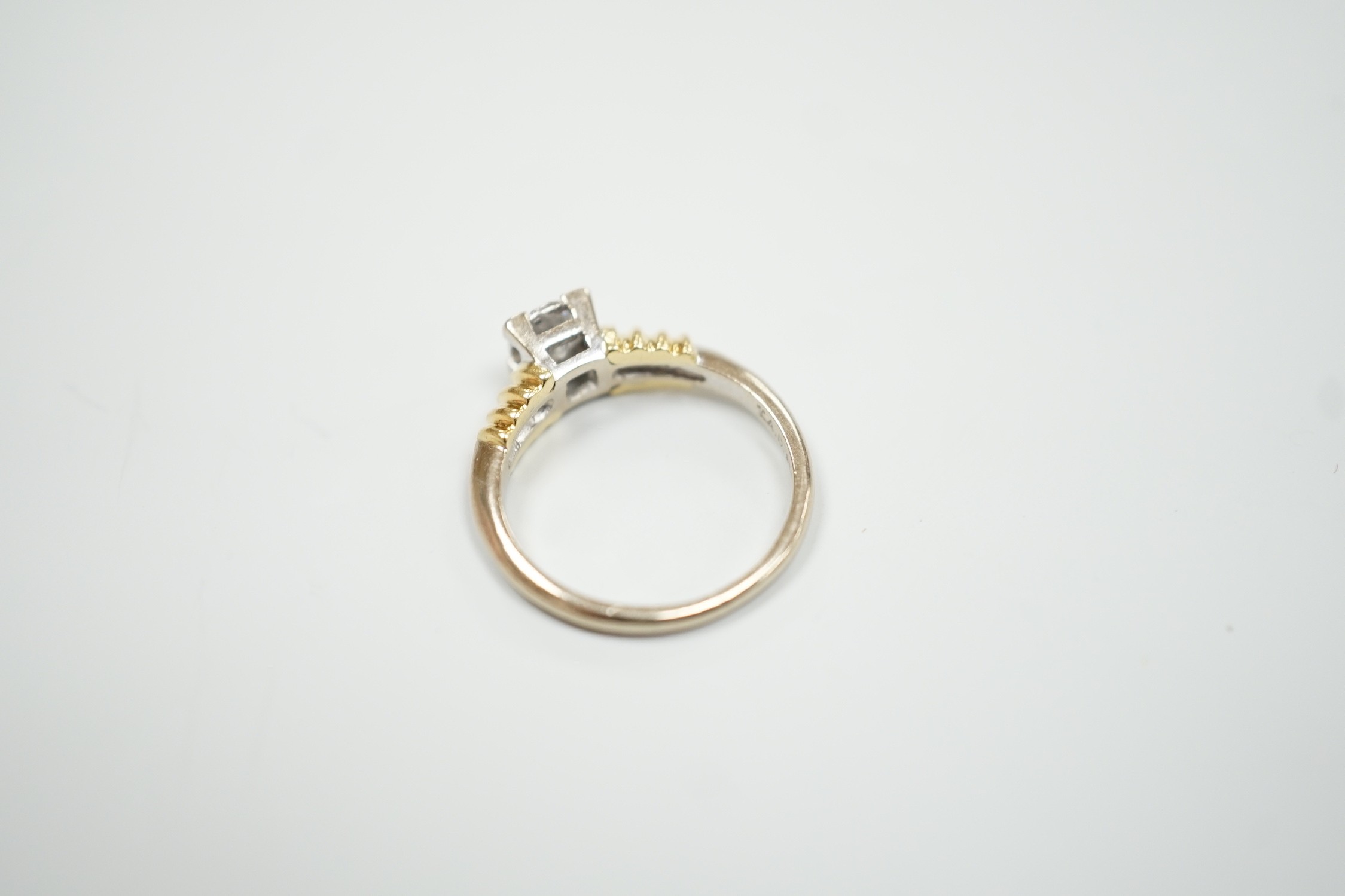 A modern 18ct two colour gold and solitaire diamond set ring, size H/I, gross weight 3.3 grams.